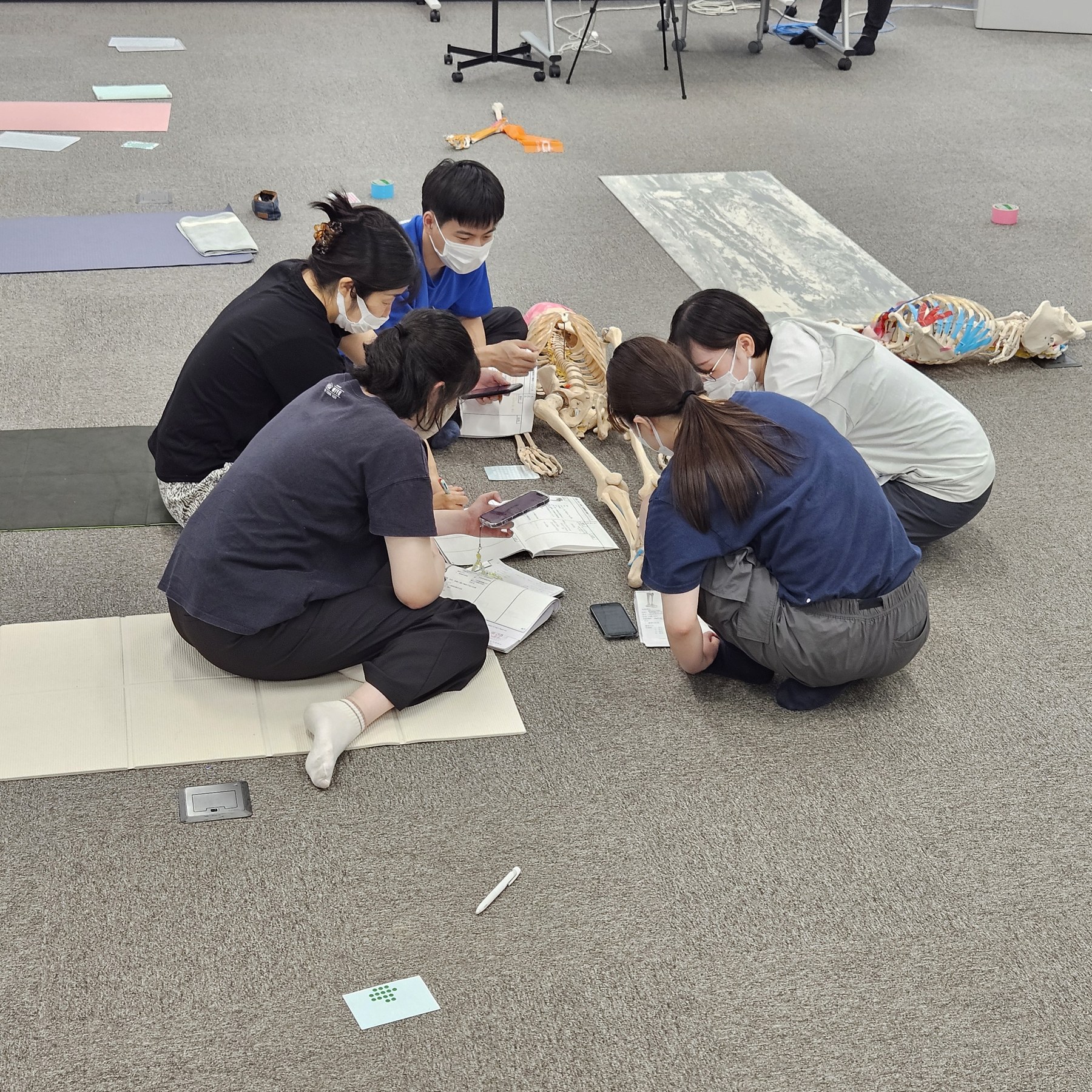 グループで骨模型と資料を囲み、触れる場所を確かめ合っている様子